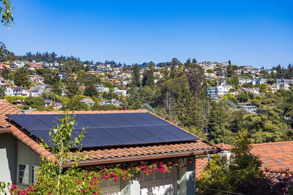 Einfamilienhaus mit Solarmodulen auf dem Dach in sonniger Wohnsiedlung